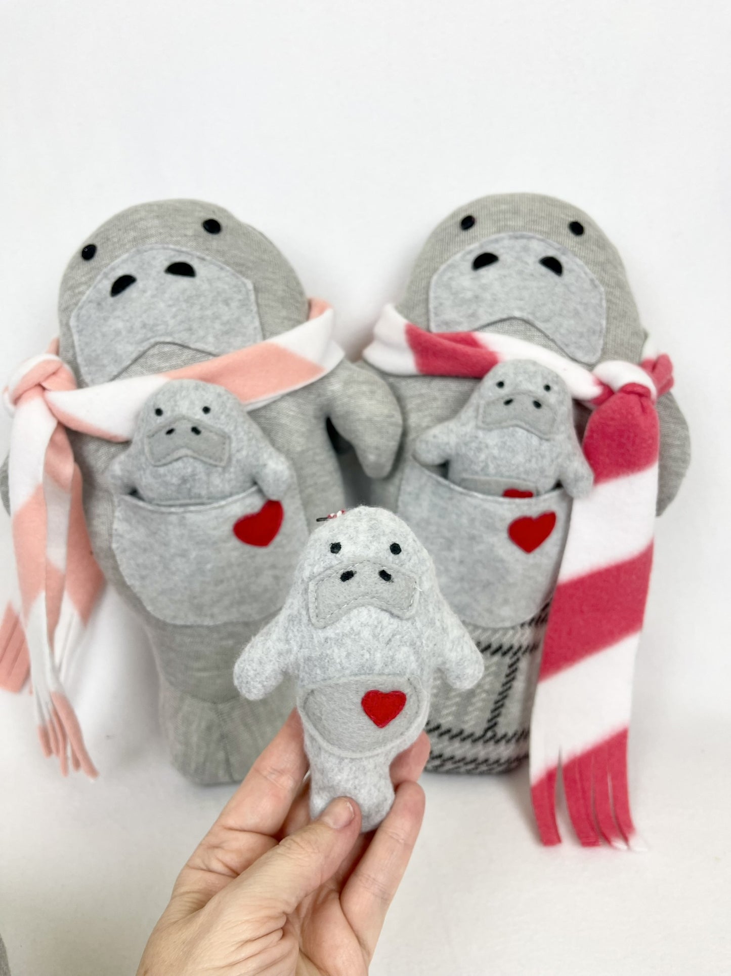 manatee stuffed animals with scarfs and babies in pockets