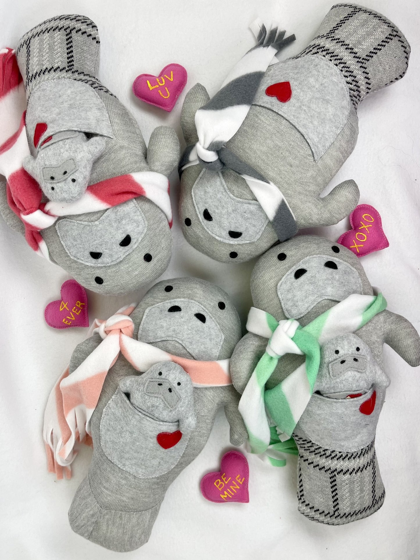 manatee stuffed animals with scarfs and babies in pockets