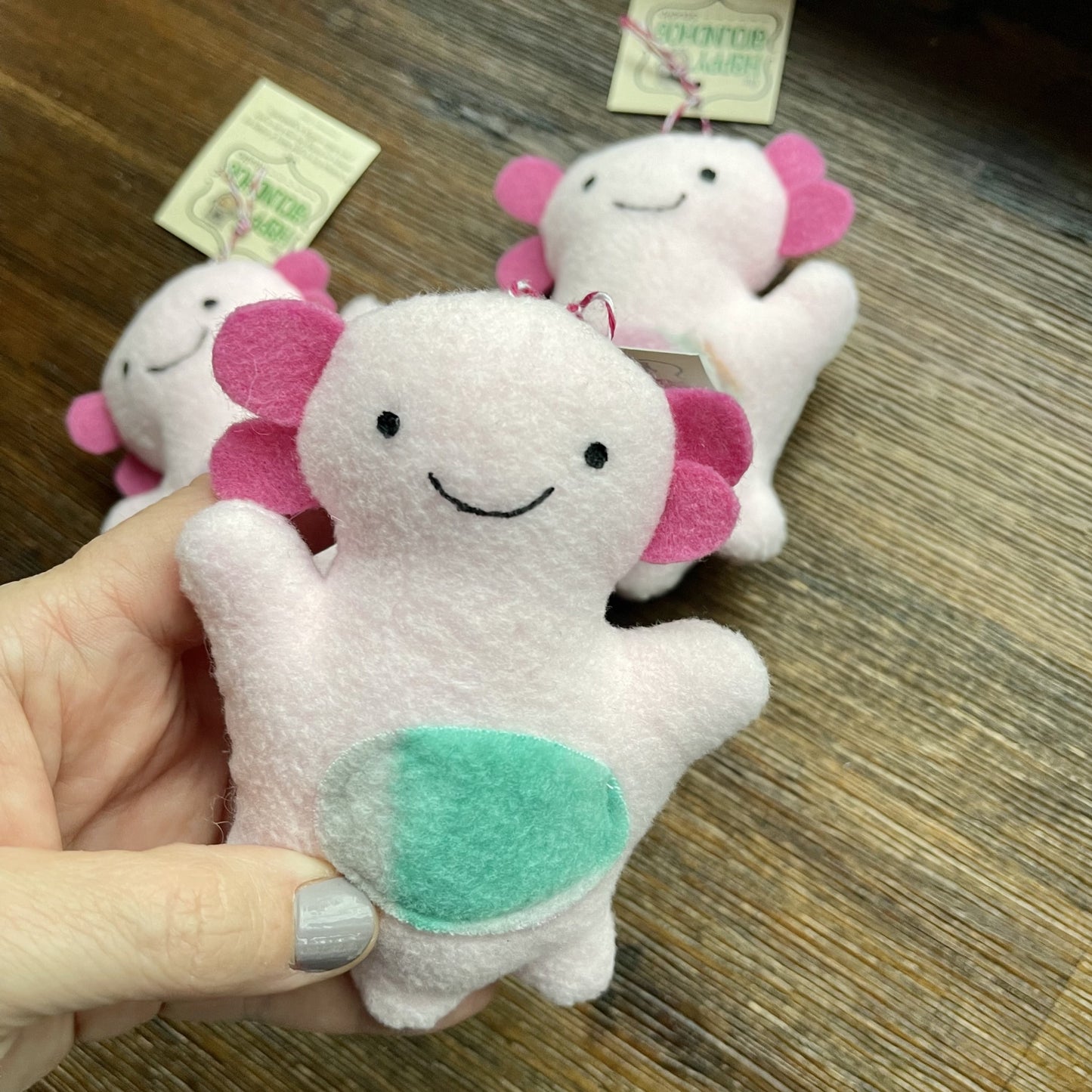 pink axolotl ornament in foreground with two more axolotl